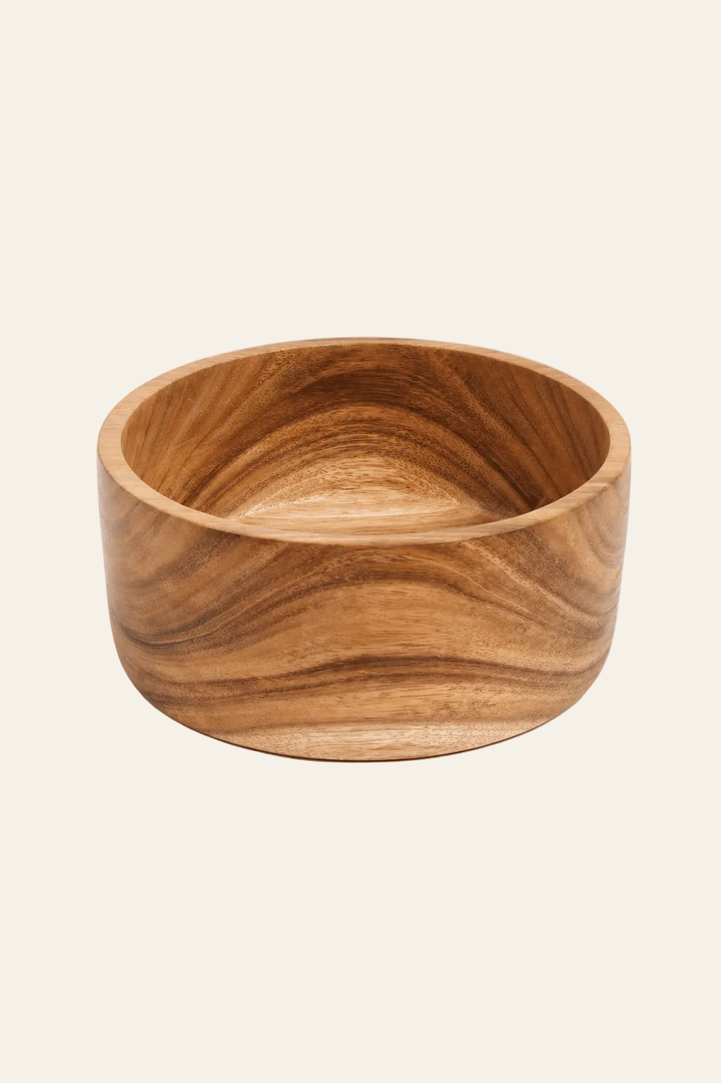 Handgemaakte saladekom van suarhout op een licht beige achtergrond als een productfoto