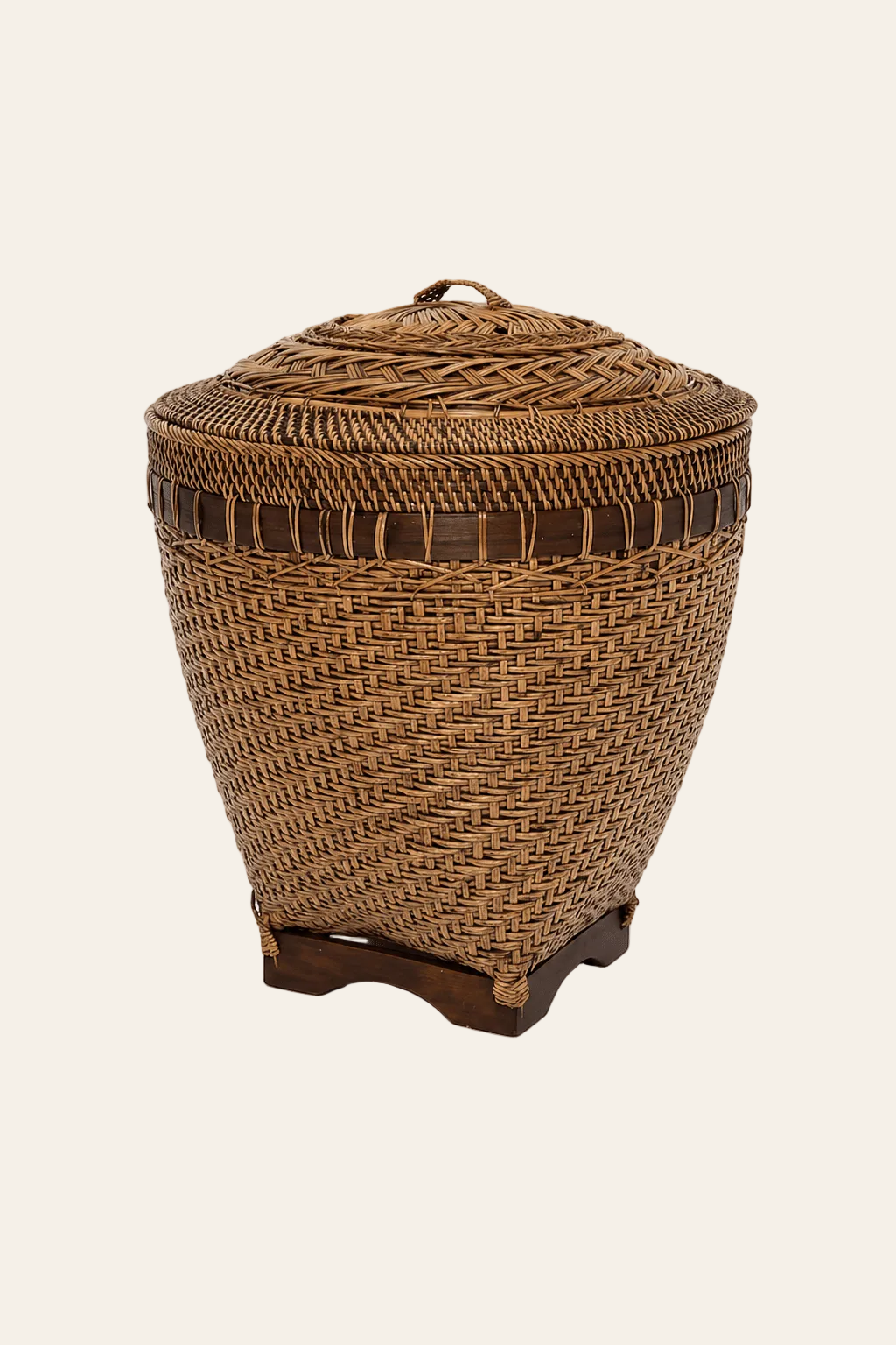 Handgevlochten rotan opbergmand met deksel op een lichte beige achtergrond