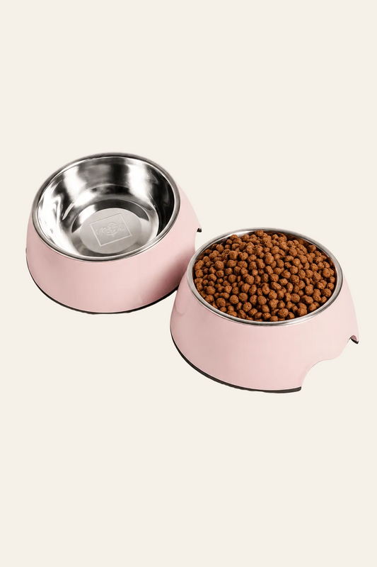 Neandno roze tweedelige voerbak van roestvrij staal en melamine op een lichtbeige achtergrond