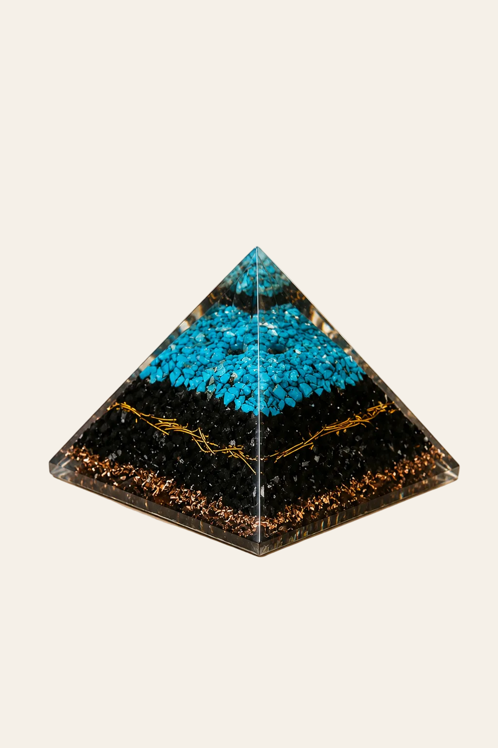 Orgoniet piramide met turquoise en zwarte toermalijn op een lichte beige achtergrond als een productfoto
