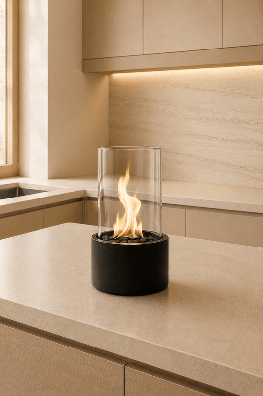 Ronde tafelhaard op bio-ethanol in zwart metaal en glas voorgesteld op een lichtbeige keuken eiland in een gezellige keuken