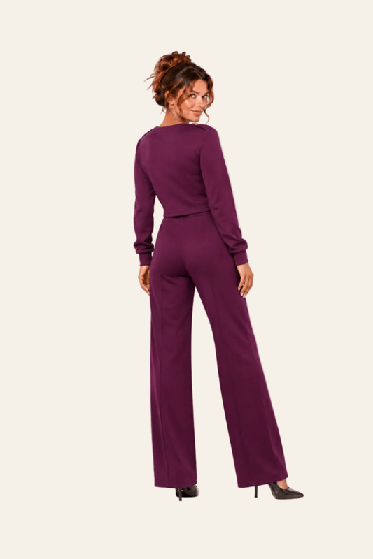 Achteraanzicht van violet LMB Boutique tweedelig damespak met sweater en broek.
