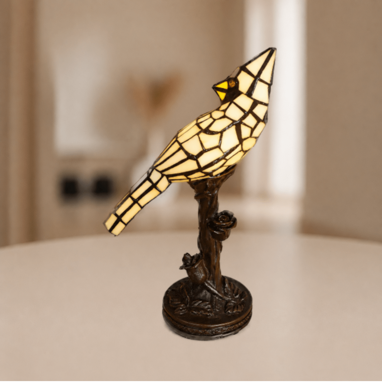 Brandende Tiffany vogellamp met beigekleurig glas-in-lood en warme gloed boven boomtakvoet