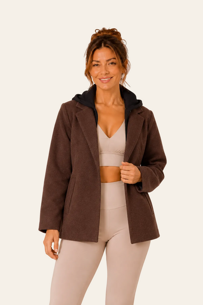 Vooraanzicht van bruine fluwelen LMB Boutique damesjas met brede sjaalkraag, knoopsluiting en zijzakken.