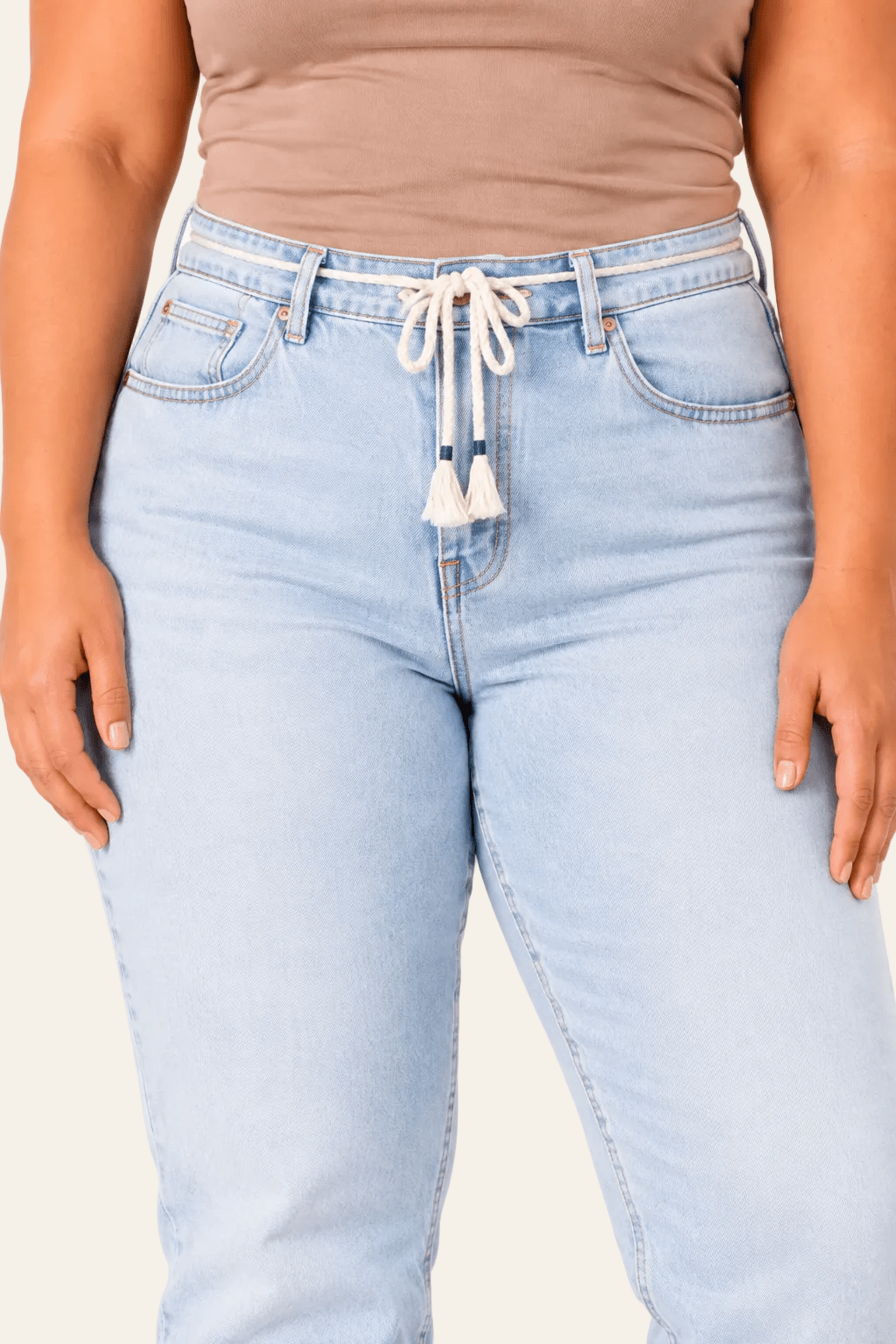 Detail van hoge taille, strikriem en insteekzakken van balloon fit damesjeans.