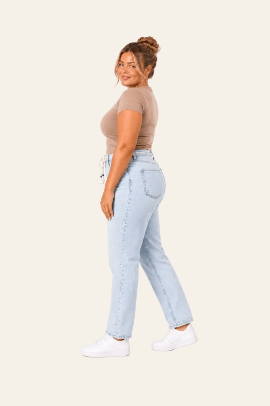 Zijaanzicht van balloon fit damesjeans met hoge taille en strikriem.