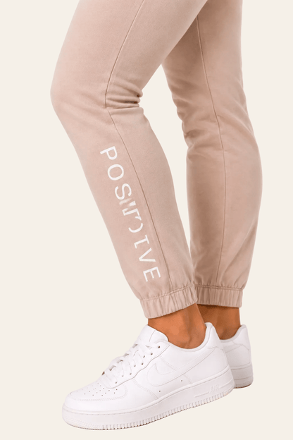 Detail van snit, naad en elastische boord van beige damesjoggingbroek.