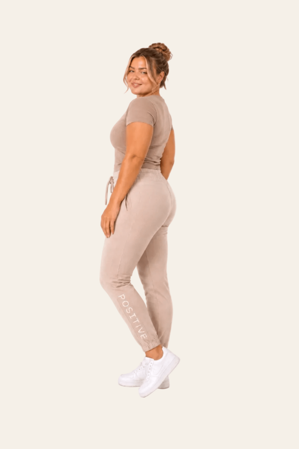 Zijaanzicht van beige high waist damesjoggingbroek met zijzakken.