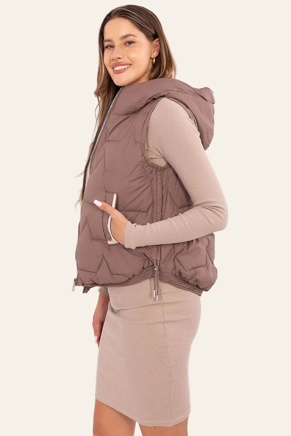 Zijkant van Beige gewatteerde damesbodywarmer met capuchon
