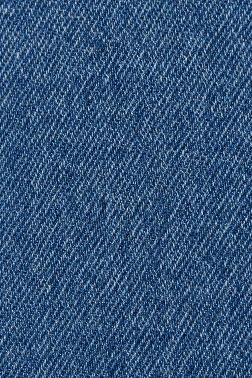 Detail van de blauwe denim stofstructuur van straight leg damesjeans.