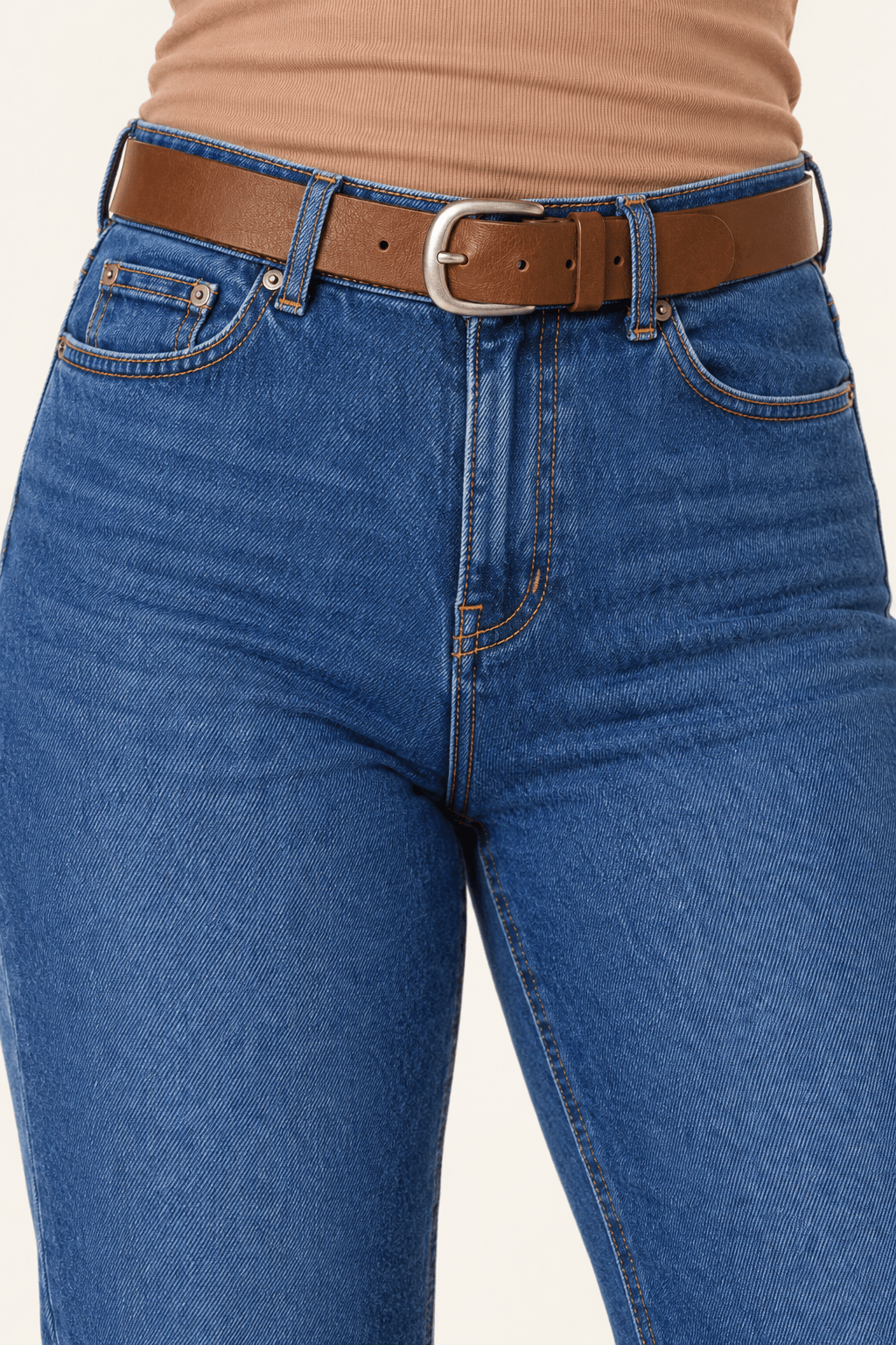 Detail van hoge taille, riem en voorzakken van blauwe straight leg damesjeans.