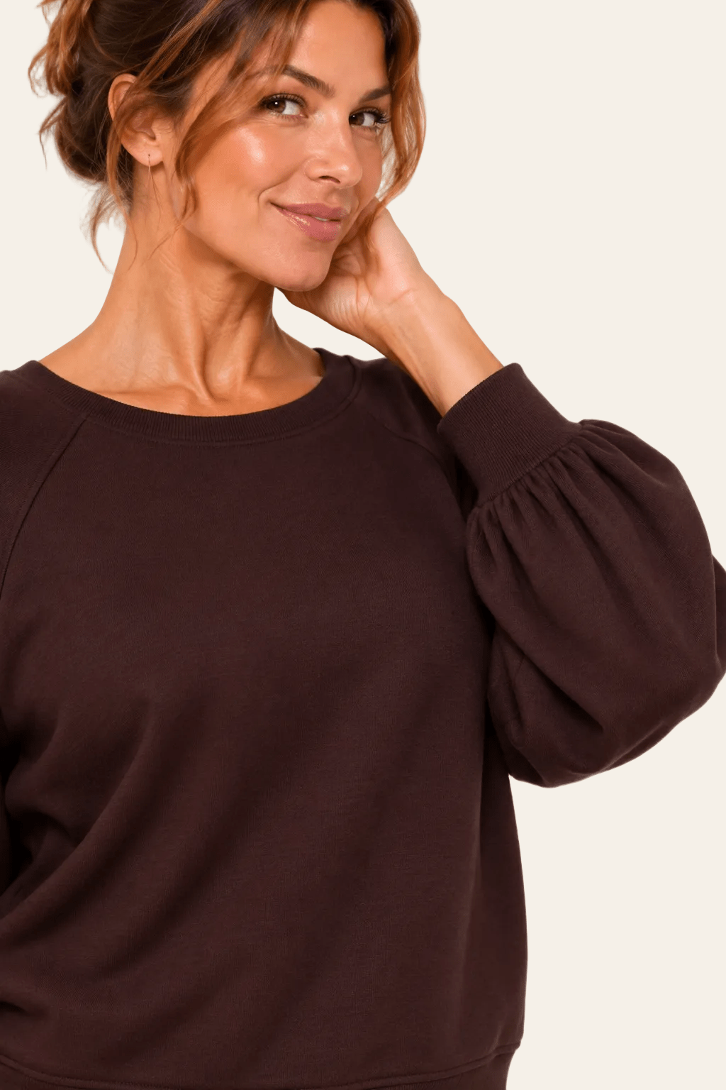 Detail van halslijn, ballonmouw en mouwuiteinde van de bruine LMB Boutique sweater.
