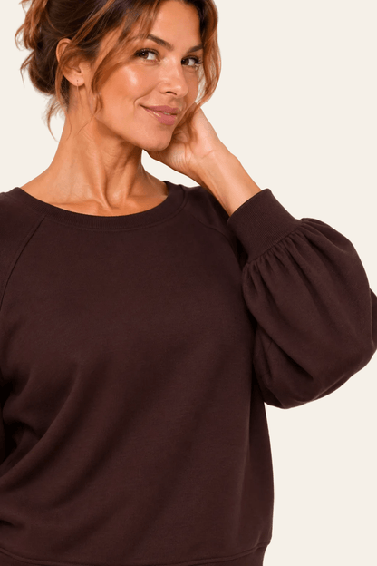 Detail van halslijn, ballonmouw en mouwuiteinde van de bruine LMB Boutique sweater.