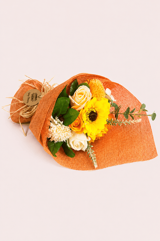 Decoratief staand boeket van oranje zeepbloemen in oranje decoratiepapier met een lint er rond als productfoto
