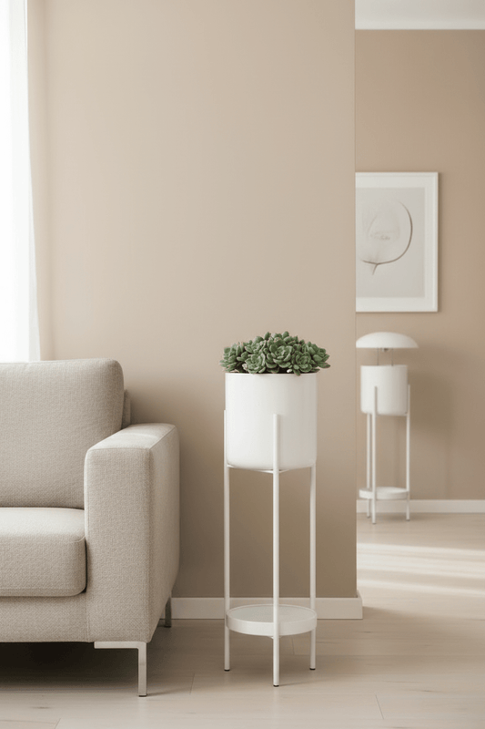 Decoratieve bloempot op standaard met kleine bloem in beige thema naast de sofa
