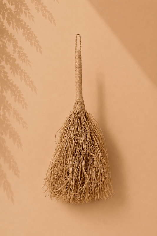 Decoratieve raffia wandbezem naturel op beige gebladerde achtergrond