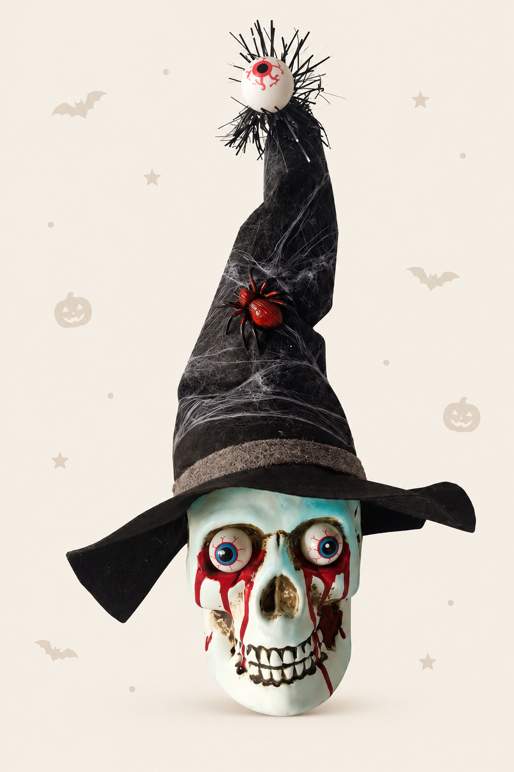 Decoratieve schedel in wit kunststof met een zwarte heksenhoed op met een dikke rode spin en vanboven op de punt van de hoed hangt een oog voor halloween
