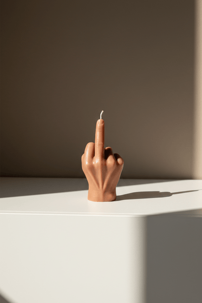 Designkaars in taupekleur met middelvinger op een kast