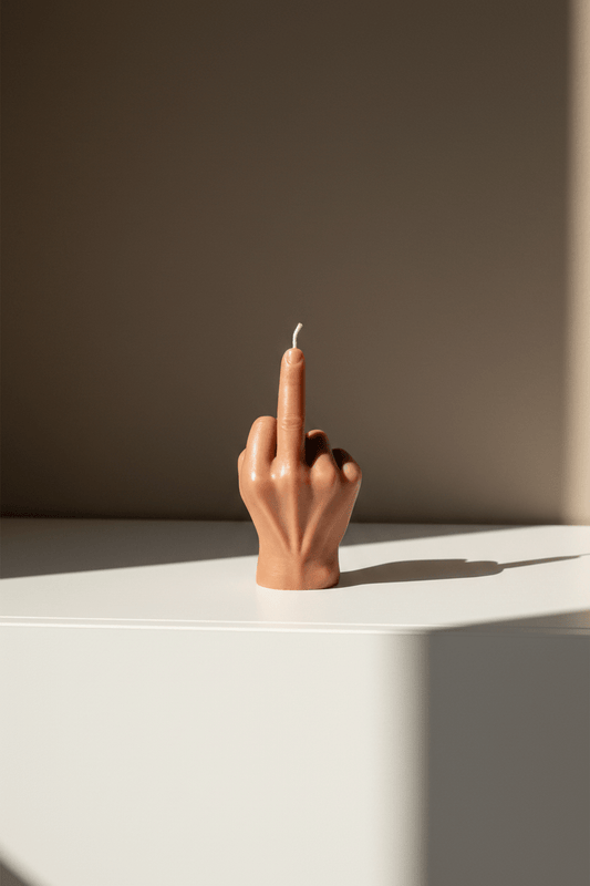 Design kaar die een middelvinger toont op een witte kast met beige muur