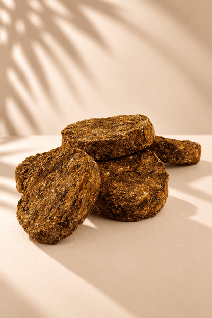Dogstar Pensburgers 5 kg, bruine ronde hondensnacks met runderpens en stevige structuur, gestapeld op een beige achtergrond.