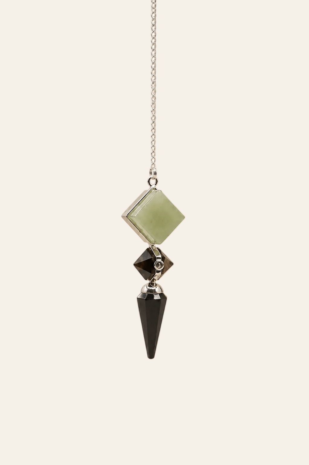 Drievoudige edelsteen pendel met zwarte agaat, groene aventurijn en tijgeroog op een licht beige achtergrond als productfoto