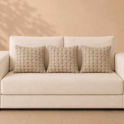 Detail van naturel linnen kussenhoes met brede kruisbinding en zichtbare textuur