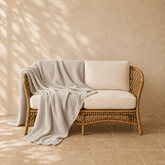 Famke fleece plaid in beigekleur 130 × 180 cm, in een verzorgde woonsetting met zichtbare textuur en vorm.