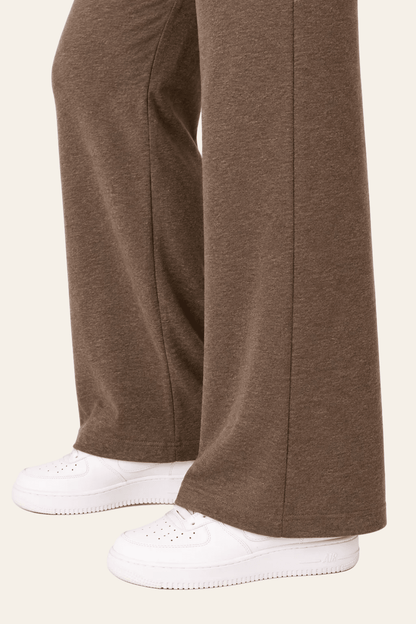 Detail van pijp, naad en zoom van bruine joggingbroek met rechte pijpen.