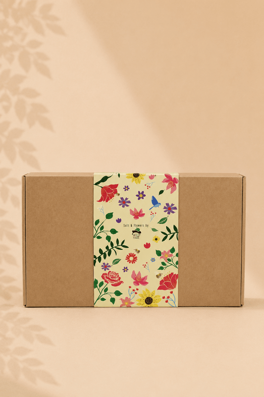 Geschenkdoos met badzout en zeepbloemen in een bruine doos met een gebloemde print rond de doos