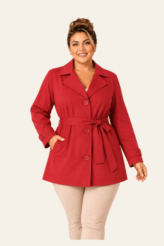 Vooraanzicht van getailleerde damestrenchcoat met tailleband en gespmanchetten.