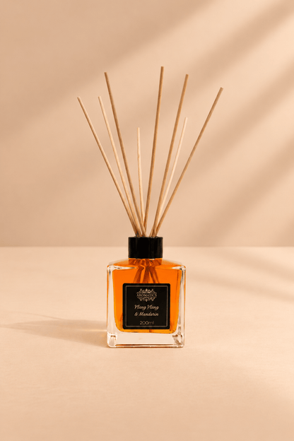 Geurstokjes ylang ylang en mandarijn 200 ml in glazen flacon met amberkleurige vloeistof op warm beige template