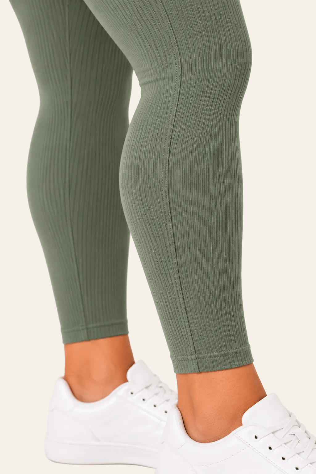 Detail van snit, naad en zoom van groene geribde dameslegging.