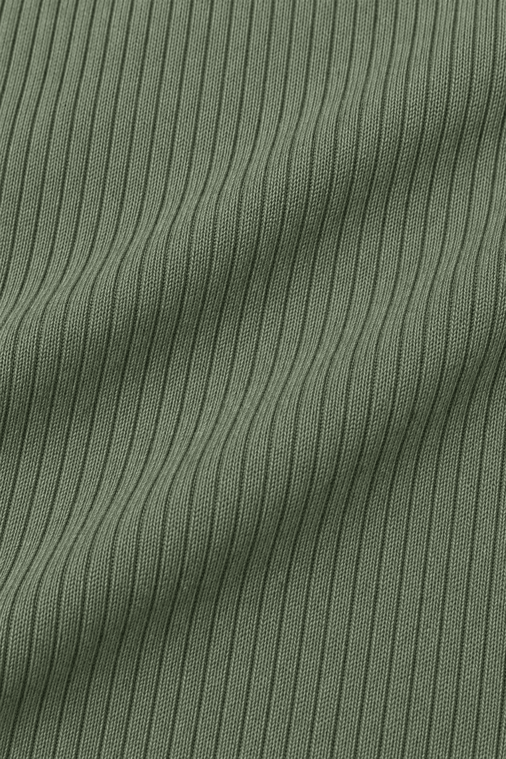 Detail van de geribde stofstructuur van groene dameslegging.
