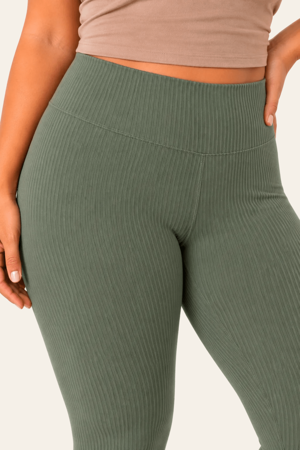 Detail van hoge taille en voorzijde van groene geribde dameslegging.