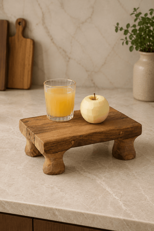 Handgemaakt teakhouten massief dienblad op pootjes op marmere keukenblad met glas sinaasappelsap en gechilde appel 30x20x10cm