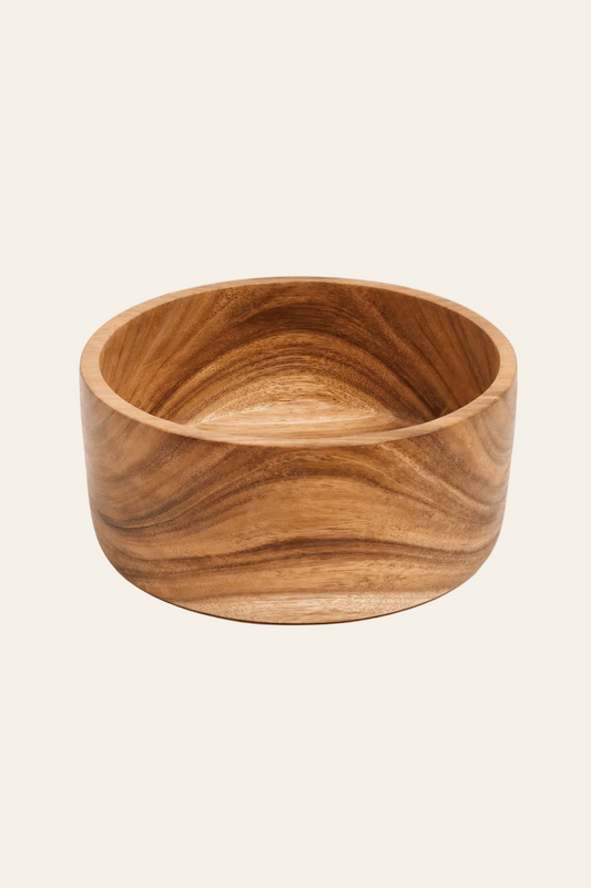 Handgemaakte saladekom van suarhout op een licht beige achtergrond als een productfoto