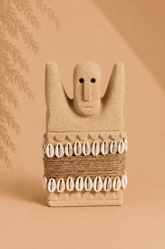 Handgesneden Sumba-beeld van zandsteen met kaurischelpen op een beige gebladerde achtergrond