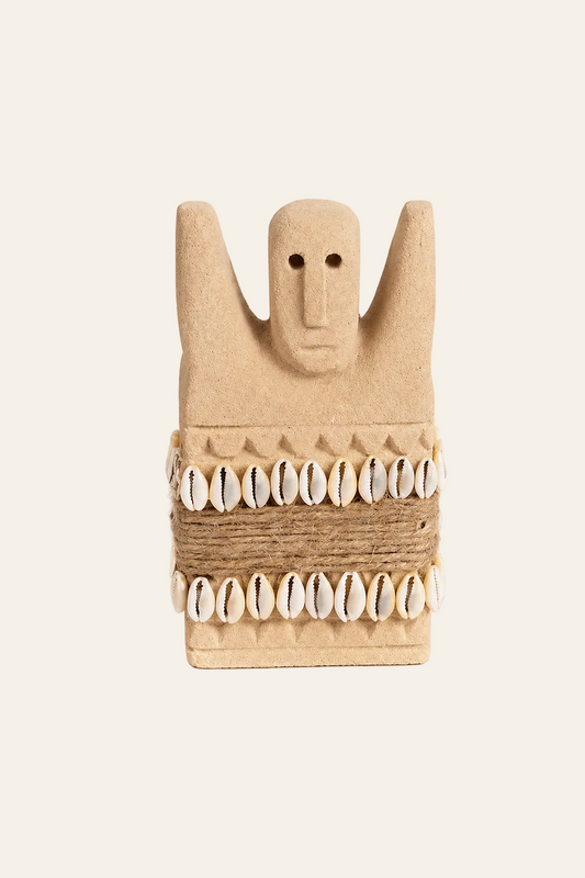 Handgesneden Sumba-beeld van zandsteen met kaurischelpen op licht beige achtergrond
