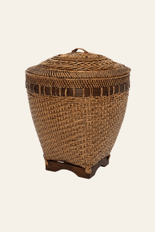 Handgevlochten rotan opbergmand met deksel op een lichte beige achtergrond