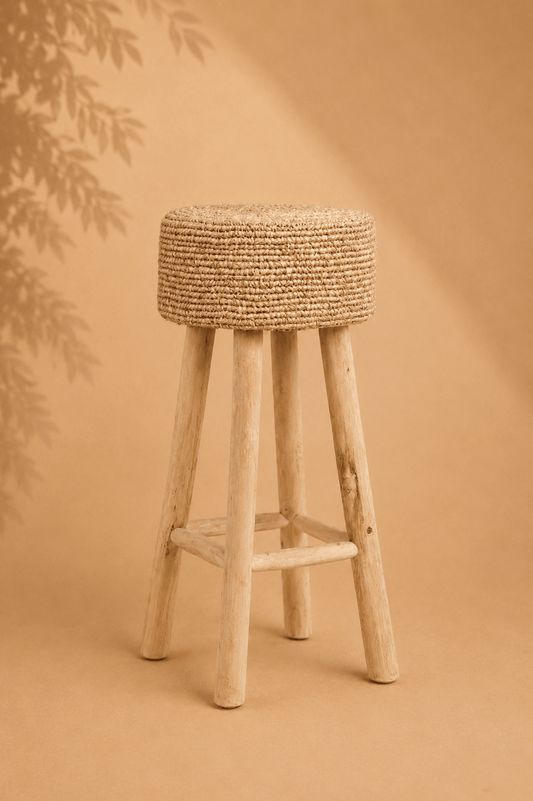 Hoge barkruk van teakhout en raffia op een beige gebladerde achtergrond