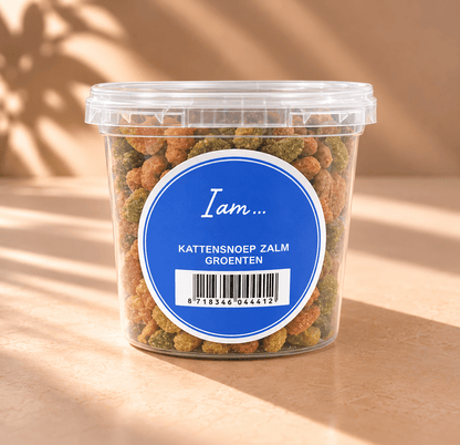 I Am kattensnacks met zalm en groenten in transparante cup van 70 gram, met blauwe ronde merksticker en meerkleurige brokjes.