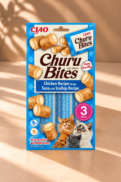 Inaba Churu Bites kattensnacks met kip, tonijn en sint-jakobsschelp, blauwe verpakking met drie zakjes van 10 gram op beige achtergrond.