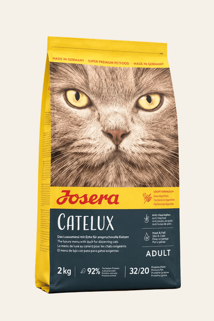 Josera Catelux kattenbrokken 2 kg in geel-zwarte verpakking met kattengezicht, droogvoer voor volwassen katten met haarballen.