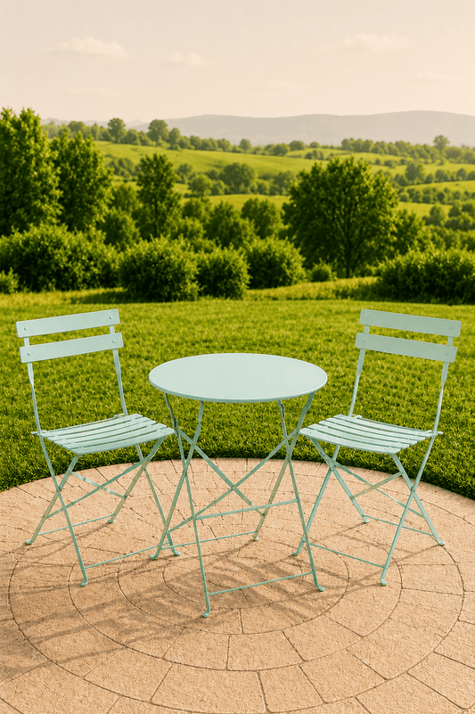 Lichtgroene metalen Laurence tuinbistroset met ronde tafel en twee stoelen op een betegeld terras met uitzicht over een groen landschap
