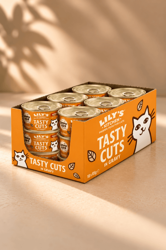 Lily's Kitchen Tasty Cuts kattenvoer met kip in saus, oranje voordeelverpakking met 18 blikjes van 85 gram op beige achtergrond.