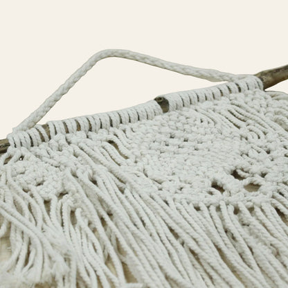 Naturel macramé wanddecoratie met houten ophangtak, gevlochten patronen en lange franjes detailfoto