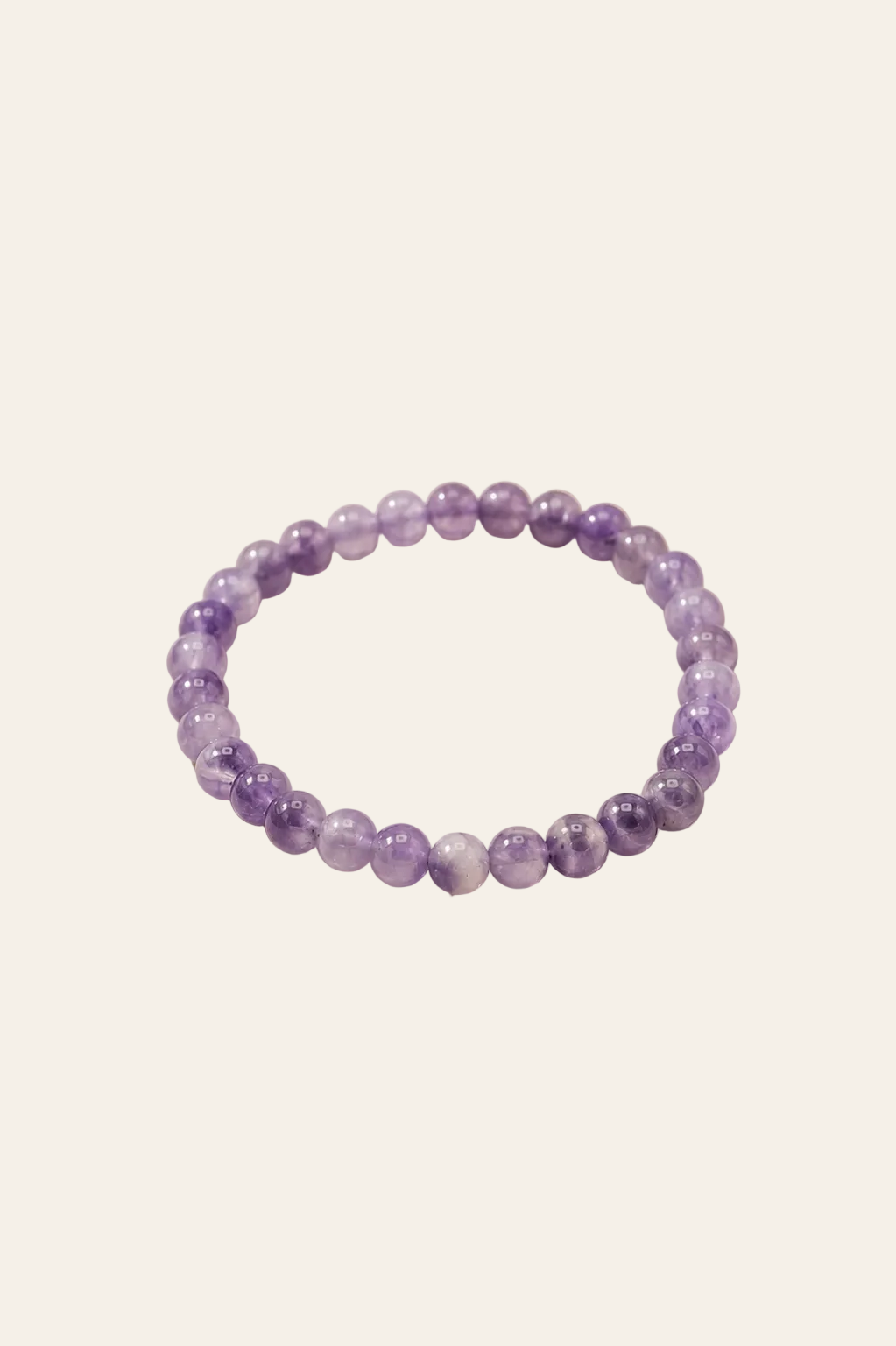 Manifestatie armband met amethist voor innerlijke rust op een licht beige achtergrond als productfoto