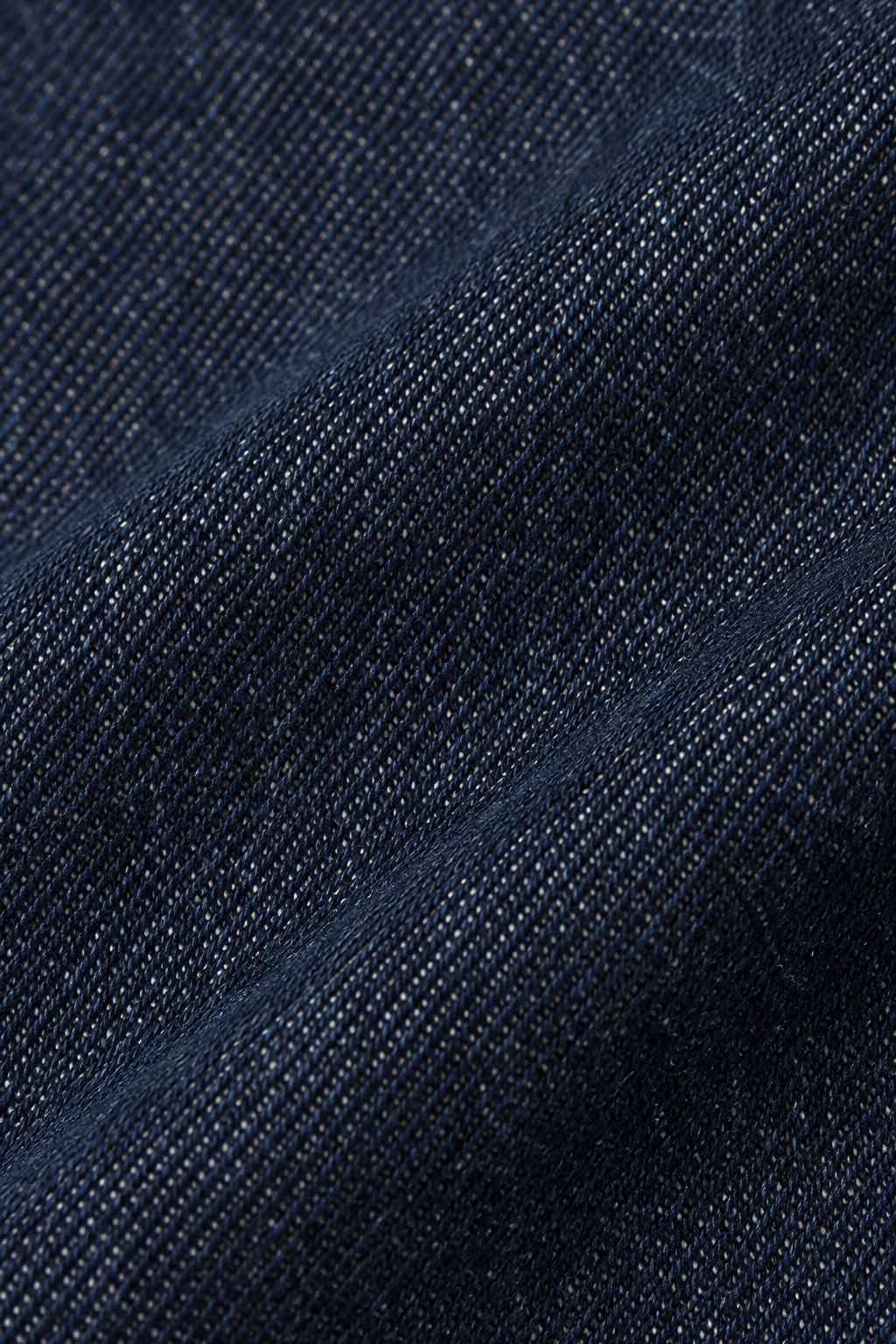 Detail van de marineblauwe denim stofstructuur van straight leg damesjeans.