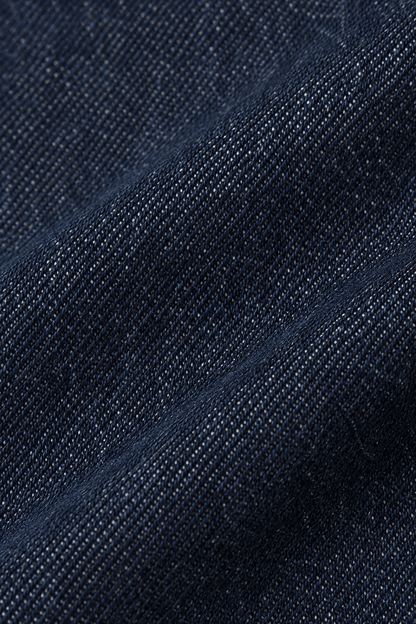 Detail van de marineblauwe denim stofstructuur van straight leg damesjeans.