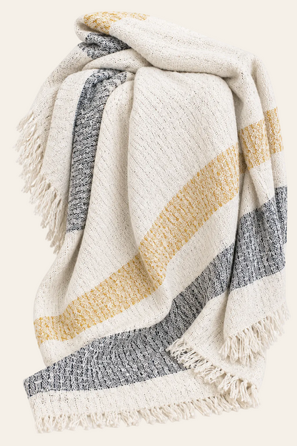 Mellow Mattala geweven katoenen plaid 125x150 cm in crème met gouden en diepgrijze strepen en decoratieve franjes op een neutrale achtergrond.
